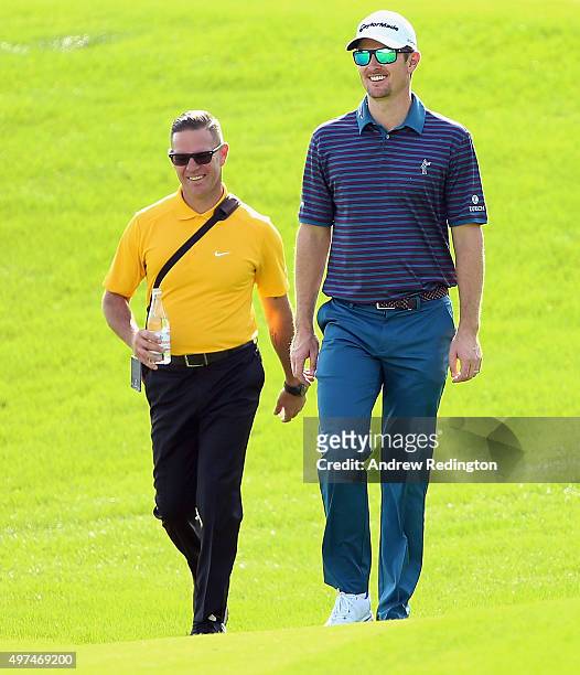 Justin Rose of England walks with his swing coach Sean Foley during practice prior to the start of the DP World Tour Championship on the Earth Course...
