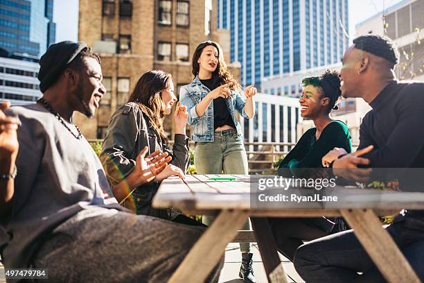 friends having fun on rooftop - garden table stock pictures, royalty-free photos & images