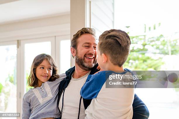 glückliche vater seine kinder begrüßung - family with two children stock-fotos und bilder