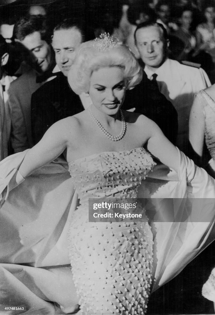 Actress Mamie Van Doren sitting showing off her gown as she arrives ...