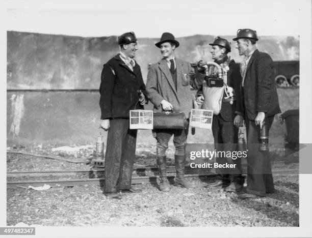 Actor Robert Donat chatting to extras during the filming of 'The Citadel' at Denham Studios, June 24th 1938.