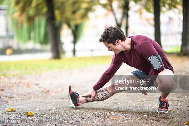 fitness man stretching the calf in berlin after run - kuit menselijk been stockfoto's en -beelden