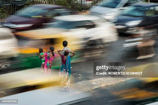 To go with Climate-warming-UN-COP21-India,FOCUS by Trudy Harris In this November 16, 2015 photo, an Indian couple with a child and a woman wait for a...