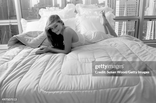 An unidentified model in a nightgown poses on a bed in a Manhattan highrise apartment, New York, New York. July 1981. The photo was taken as part of...