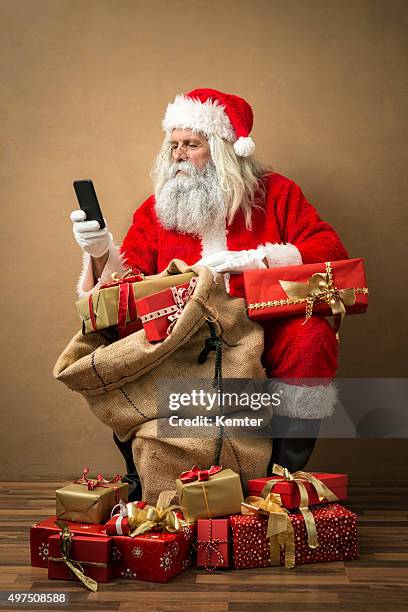 santa claus mit viele geschenke und telefon - santa sack stock-fotos und bilder