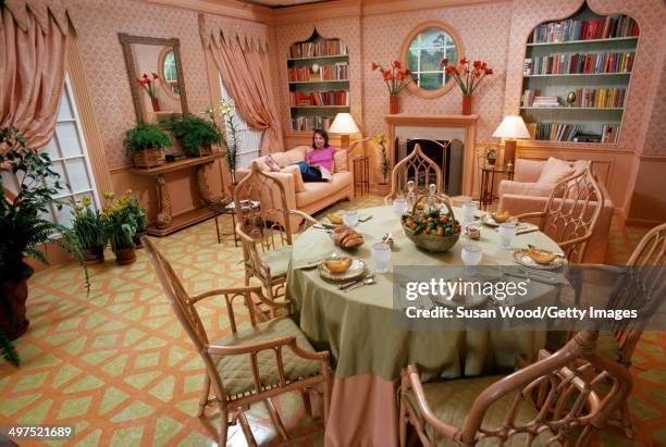 American socialite Lee Radziwill lies on a couch and shows off her dining room, March 1976.