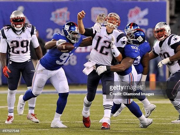 Quarterback Tom Brady of the New England Patriots is strip-sacked by linebacker Jasper Brinkley of the New York Giants during a game on November 15,...
