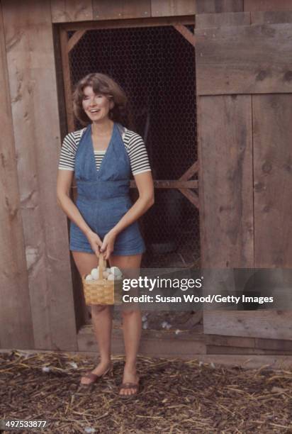 American businesswoman Martha Stewart carries a basket of eggs from a chicken coop on the grounds of her home, Westport, Connecticut, August 1976.