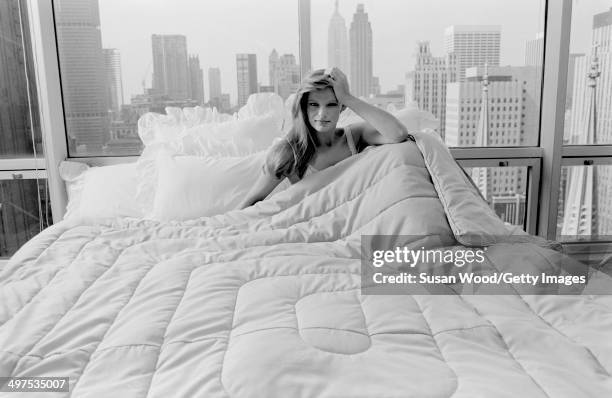 An unidentified model in a nightgown poses in a bed in a Manhattan highrise apartment, New York, New York. July 1981. The photo was taken as part of...