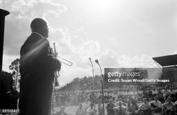 American jazz musician Louis Armstrong and his All-Star Band performs at an outdoor venue during a tour of Africa, late 1960.