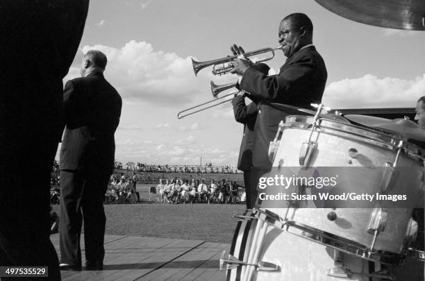 American jazz musician Louis Armstrong and his All-Star Band performs at an outdoor venue during a tour of Africa, late 1960.