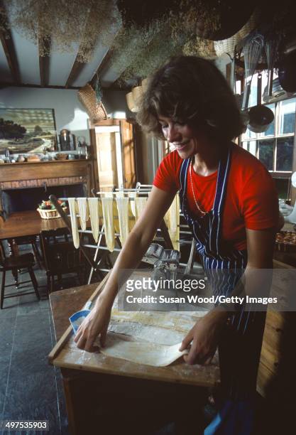 American businesswoman Martha Stewart lays out pasta on a wooden board atop a table in her kitchen, Westport, Connecticut, August 1976.
