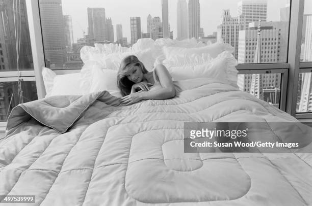 An unidentified model in a nightgown poses in a bed in a Manhattan highrise apartment, New York, New York. July 1981. The photo was taken as part of...