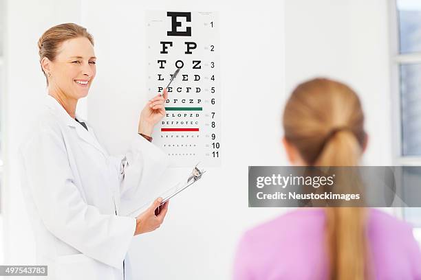 optometrist checking girl's eyesight - sight test chart stock pictures, royalty-free photos & images