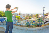 Tourist taking photos with smartphone in Gaudi's Park Guell, Barcelona