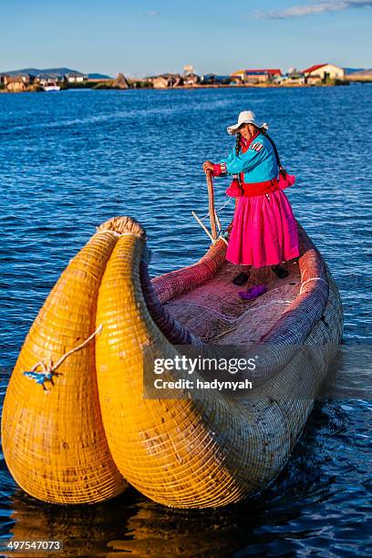 peruvian woman sailing between uros floating islands, lake tititcaca - indigenous south american culture stock pictures, royalty-free photos & images
