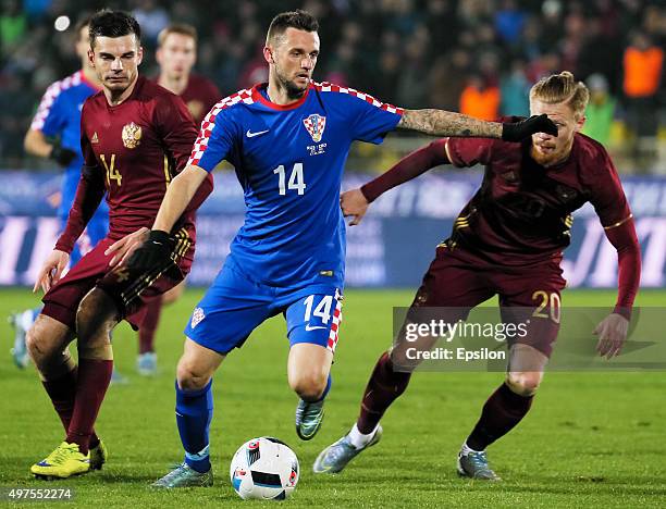 Artur Yusupov and Andrei Semyonov of Russia is challenged by Marcelo Brozovic of Croatia during the international friendly football match between...