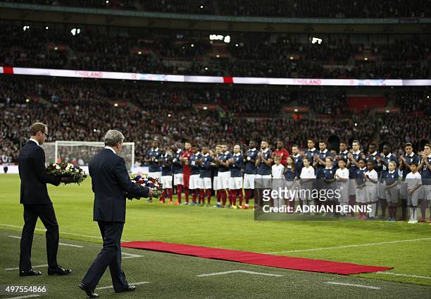 Britain's Prince William and England manager Roy Hodgson carry floral tributes before the start of the friendly football match between England and...