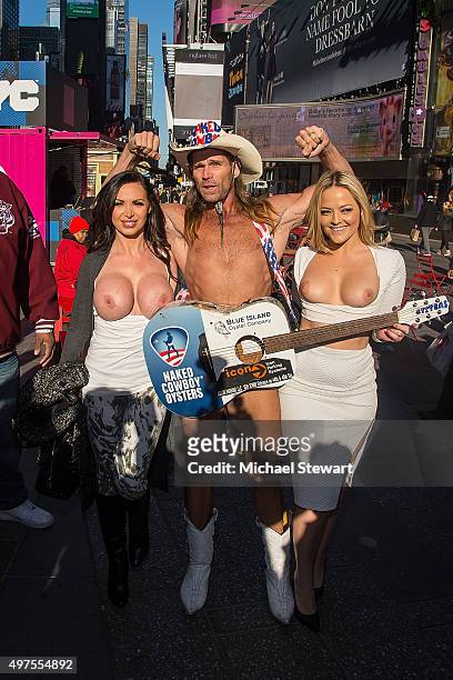 Adult actresses Nikki Benz and Alexis Texas pose topless with the Naked Cowboy in celebration of gender liberation in Times Square on November 17,...