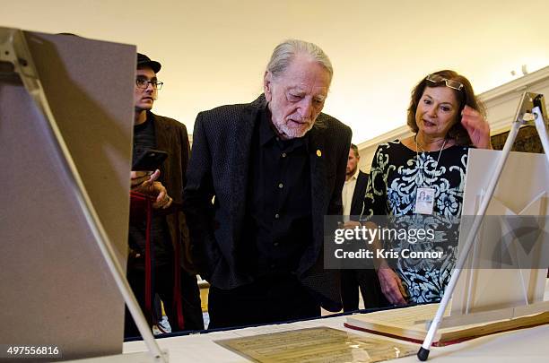 Willie Nelson with wife Annie D'Angelo check out artifacts after attending the 2015 Gershwin Prize Luncheon where he was honored with a certificate...