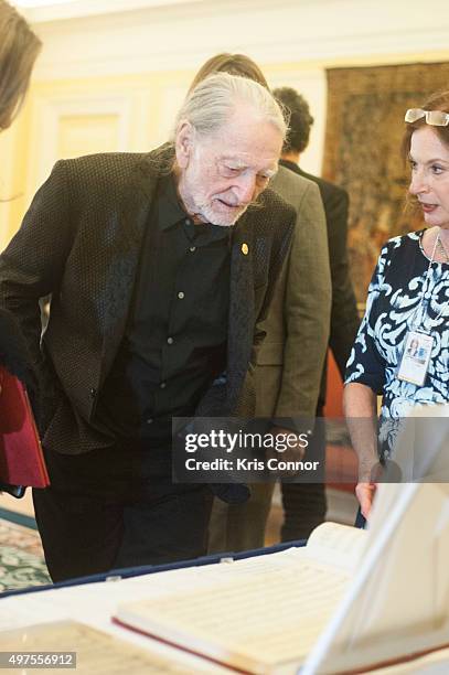 Willie Nelson check out artifacts after attending the 2015 Gershwin Prize Luncheon where he was honored with a certificate and an American flag in...