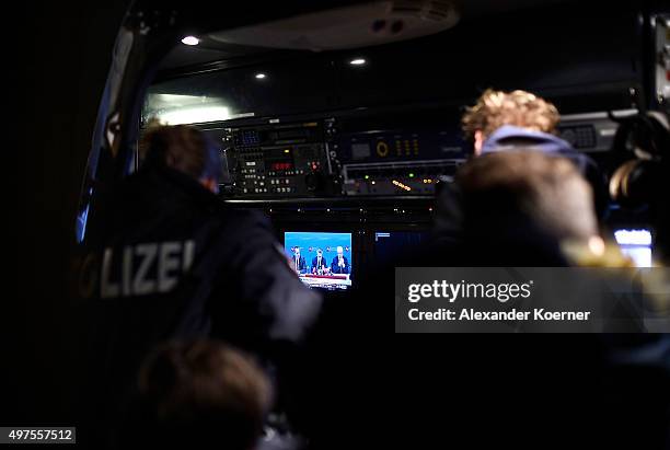 Members of the public and police forces watch a live stream of the German Minister of the Interior Thomas de Maiziere close to the HDI-Arena on...