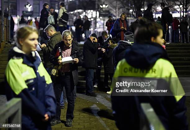 People react shortly after the match between Germany and the Netherlands was cancelled following a bomb alert at the HDI-Arena on November 17, 2015...