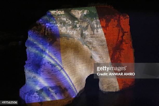 Picture taken on November 17, 2015 shows Beirut's landmark of Rawshe illuminated with the French national colours during a ceremony in tribute to the...