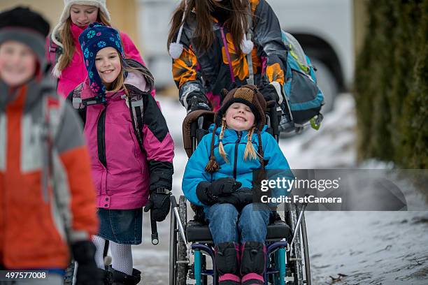 mädchen, die in einem rollstuhl gedrückt - child in wheelchair stock-fotos und bilder