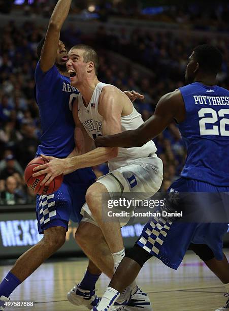 Marshall Plumlee of the Duke Blue Devils is fouled by Alex Poythress of the Kentucky Wildcats as he tries to drive between Poythress and Marcus Lee...