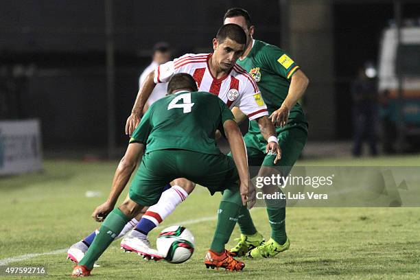 Derlis Gonzalez of Paraguay fights for the ball with Jorge Flores and Damian Lizio of Bolivia during a match between Paraguay and Bolivia as part of...