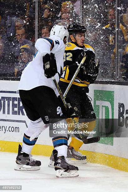 Frank Vatrano of the Boston Bruins is checked into the boards by Paul Martin of the San Jose Sharks during the third period at TD Garden on November...
