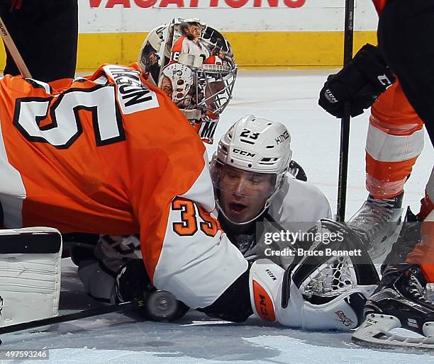 The puck bounces in front of Dustin Brown of the Los Angeles Kings as he is held by goaltender Steve Mason of the Philadelphia Flyers during overtime...