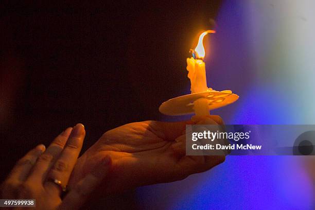 Candle is held at a memorial and vigil outside City Hall for the victims of the Paris attacks, on November 17, 2015 in Los Angeles, California....