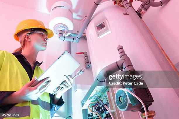 female electrician checking boiler - boiler engineer stockfoto's en -beelden