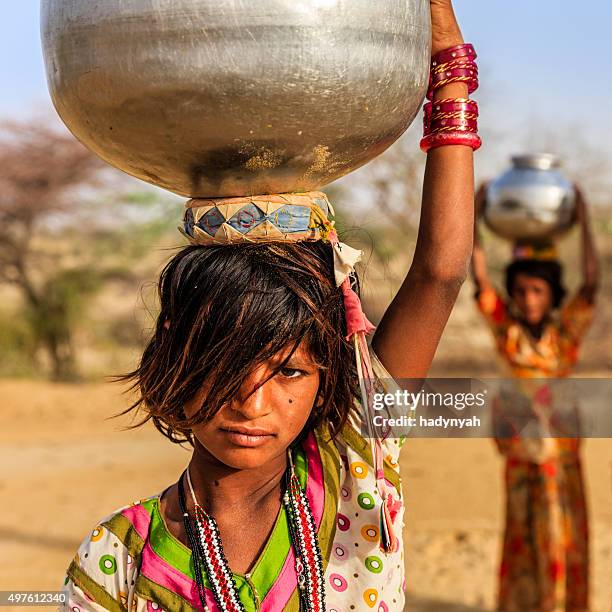 indische mädchen tragen von wasser auf den kopf gut - kinderarbeit stock-fotos und bilder
