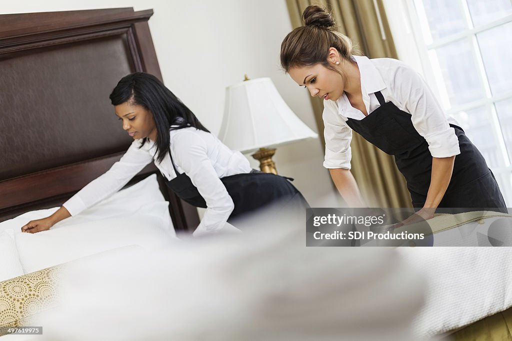 Equipa de hotel maids de luxo suite quarto de limpeza