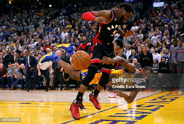 Harrison Barnes of the Golden State Warriors dives to save the ball from going out of bounds as DeMarre Carroll of the Toronto Raptors looks on at...