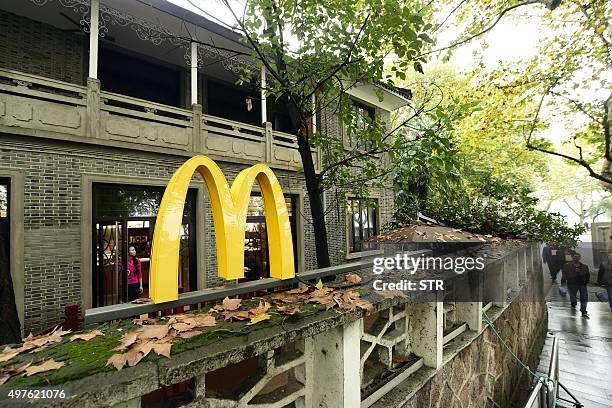 This picture taken on November 17, 2015 shows people walking past a McCafe near the famed West Lake tourist spot in the former home of late Taiwanese...