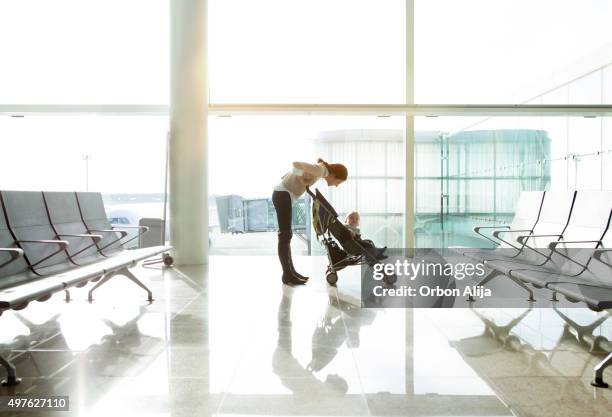 mutter mit baby auf den flughafen - baby stroller stock-fotos und bilder