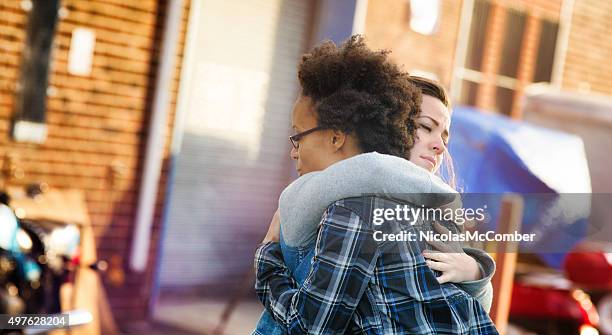 young women forgiving each other with a hug - apologize stockfoto's en -beelden