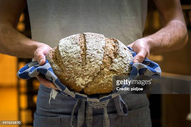 baker con pane fresco e caldo. - pane a lievito naturale foto e immagini stock