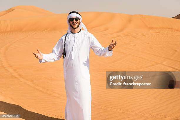 arabic man smiling on the desert - dish dash stock pictures, royalty-free photos & images