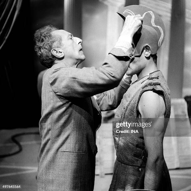 Jean Cocteau adjusting the costume of guard which carries Charles Denner the shooting of "The Infernal machine"