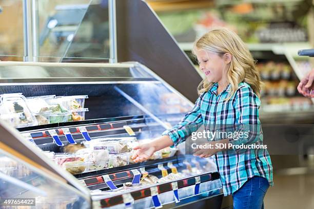 little girl shopping at deli counter with mom in supermarket - gemaksvoedsel stockfoto's en -beelden