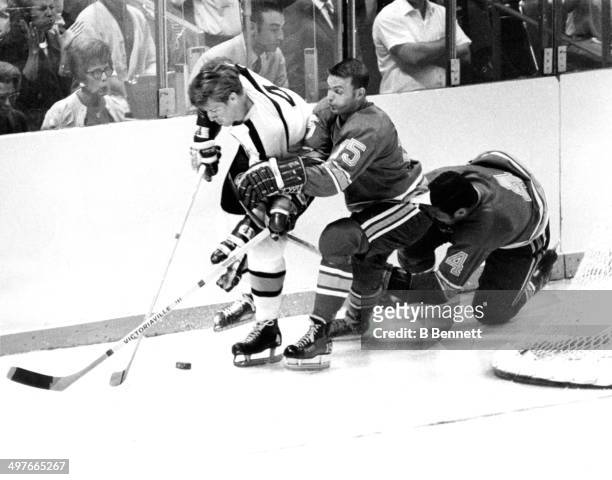 Bobby Orr of the Boston Bruins skates with the puck as he is defended by Bill McCreary and Noel Picard of the St. Louis Blues during Game 1 of the...