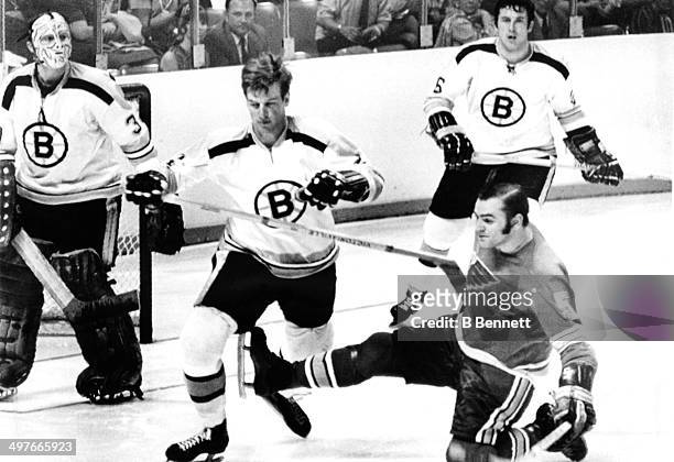 Bobby Orr of the Boston Bruins is tripped by Bob Plager of the St. Louis Blues as Orr's teammates goalie Gerry Cheevers and Don Awrey look on during...