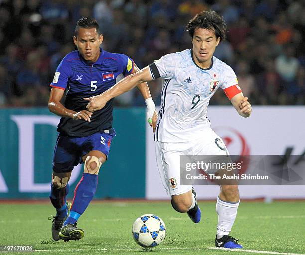 Shinji Okazaki of Japan and Soeuy Visal of Cambodia compete for the ball during the 2018 FIFA World Cup Qualifier match between Cambodia and Japan at...