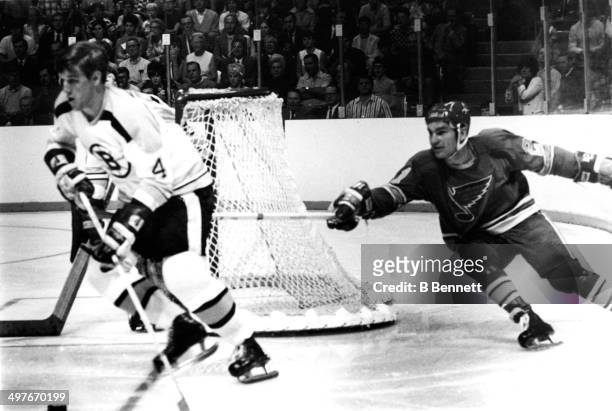 Bobby Orr of the Boston Bruins skates with the puck as he is followed by Camille Henry of the St. Louis Blues during Game 2 of the 1970 Stanley Cup...