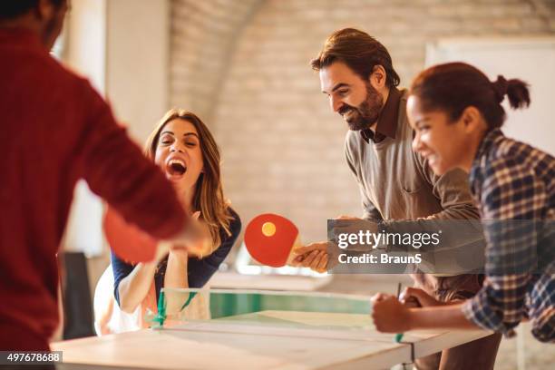 happy start up team having fun while playing table tennis. - office ping pong stock pictures, royalty-free photos & images